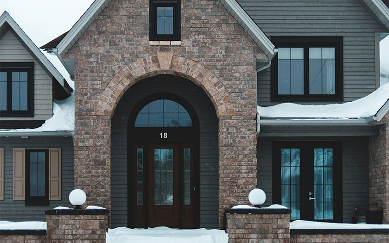 High-performance windows on a snowy home exterior, representing top winter window options for cold Canadian climates